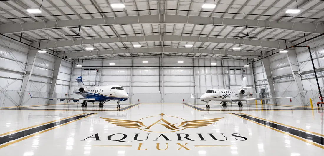 Custom black and gold Aquarius Lux logo on a white hangar floor